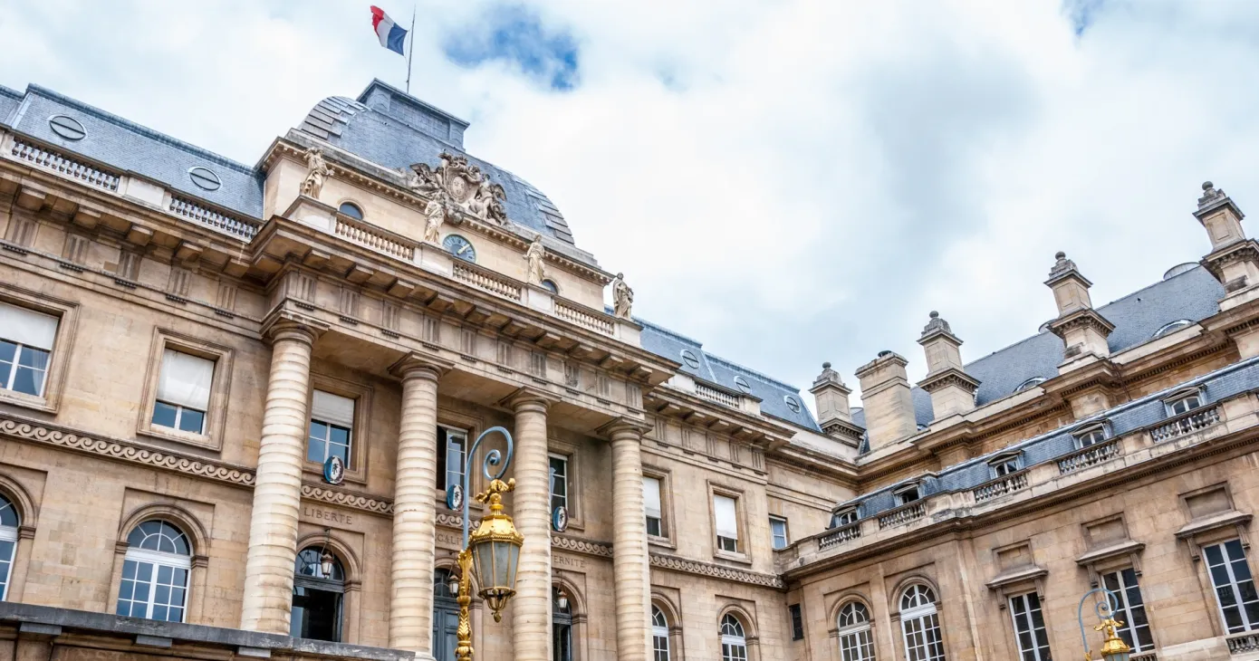 Façade du Palais de justice de Paris en contre-plongée, drapeau français au sommet