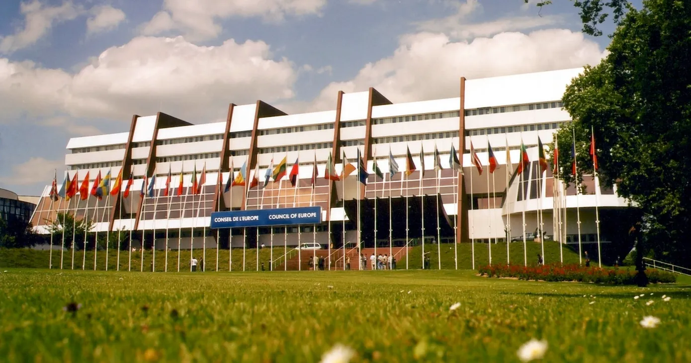 Le Palais de l’Europe à Strasbourg, drapeaux des États membres alignés devant le bâtiment.